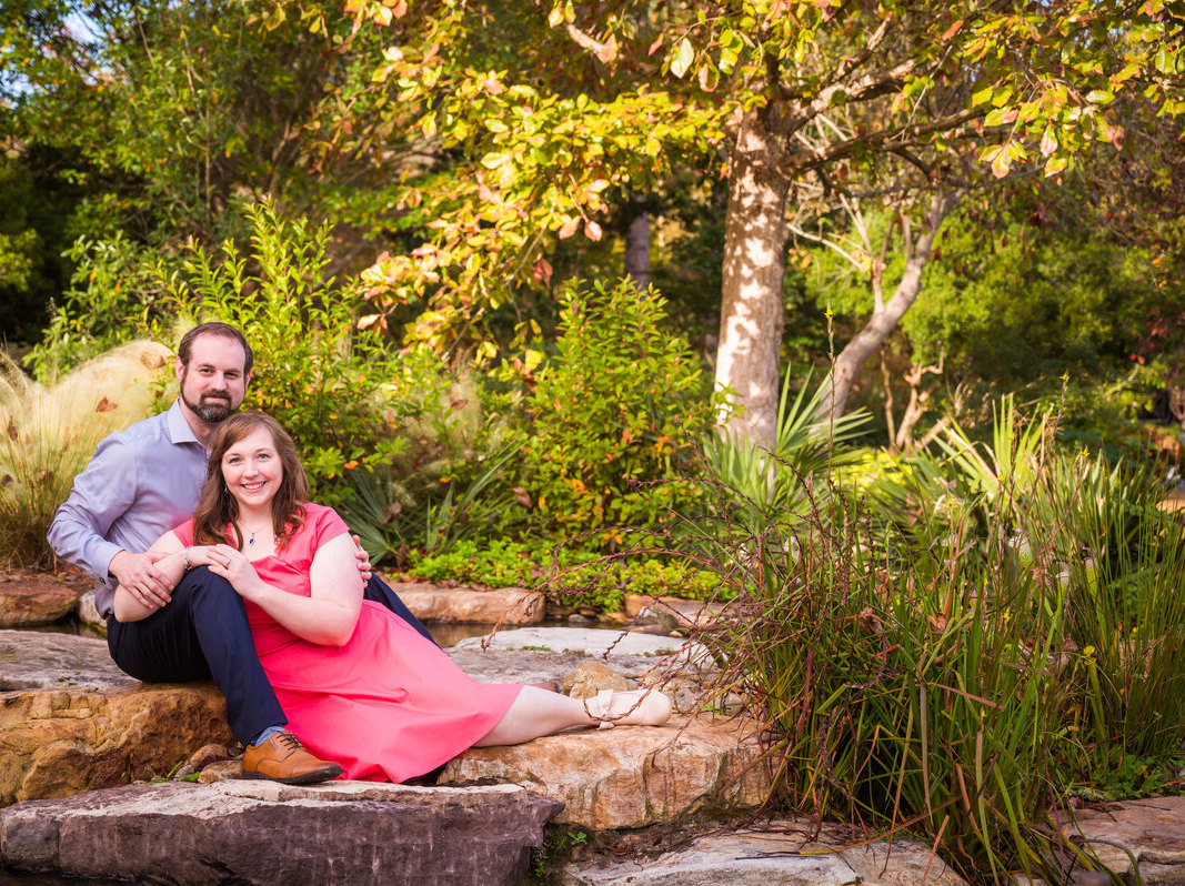 Matthew and Brittany sitting on stones by a small brook